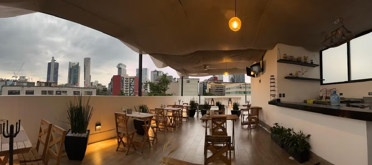 Terraza rooftop de Casa Romita con skyline de Ciudad de México al fondo